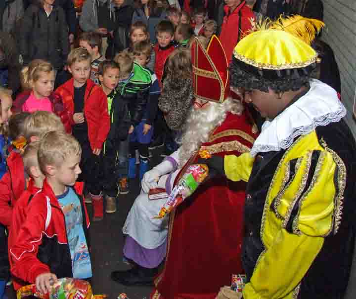 Sinterklaasviering op school met cadeautjes en kinderen in de rij